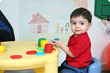 Pre school child sitting at table playing with toys